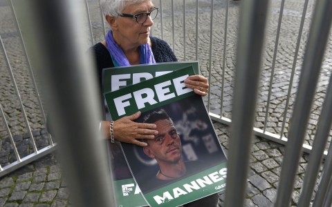 The mother of Dutch Greenpeace activist Mannes Ubels holds a poster with her son's picture as she demonstrates 