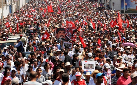 Tunisians join the funeral procession of opposition leader Mohamed Brahmi after it left his home in the Tunis suburb of Ariana on July 27, 2013