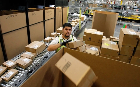 Ricardo Sandoval places packages in the right shipping boxes at an Amazon.com fulfillment center, in Phoenix on Nov. 11, 2010. (Ross Franklin/AP)