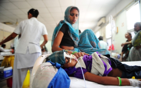 An Indian child suffering from diarrhea lies on a bed at a Government children's hospital.