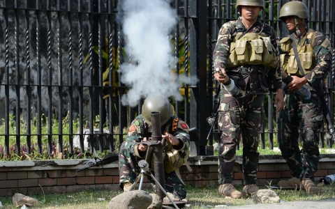 Philippine soldiers fire a 60mm mortar towards Muslim rebels position in the eight-day standoff.