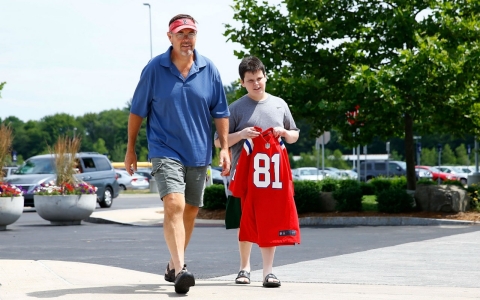 New England Patriots walk toward the stadium to trade in their Aaron Hernandez jerseys during a free exchange offered by the team following Hernandez's arrest.