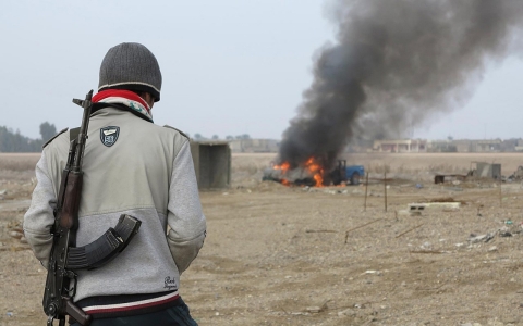 Islamic State of Iraq and Levant (ISIL) gunmen walk in the streets of the city of Fallujah on Friday.