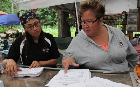 Gwaans, who also goes by her English name Beverley Clifton Percival (right), and Skayan (Anita Davis) (left) sorts through eviction notices that the Gitxsan First Nation is delivering to companies involved in resource-based industries such as logging. 