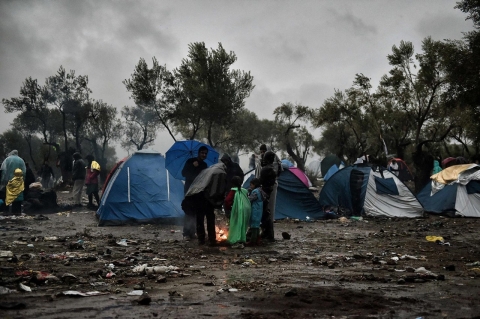 Migrants wait in heavy rain outside the Moria registration camp on Oct. 23. 