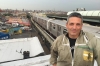 Andrew Coté stands in front of the train a rooftop where he keeps beehives in Bushwick, Brooklyn.